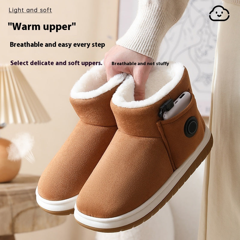 Brown heated slippers held by hand, showing soft upper